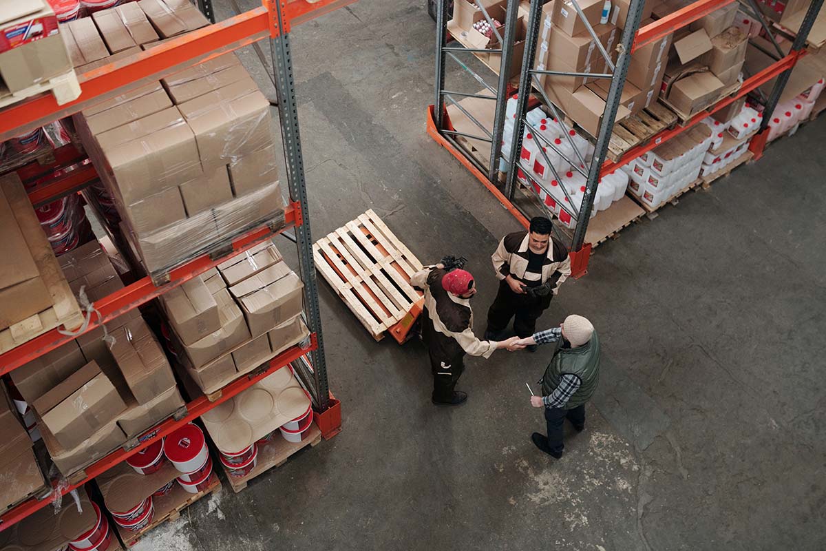 Maximing-Business-Value-Key-Employees Photo of warehouse with employees shaking hands/